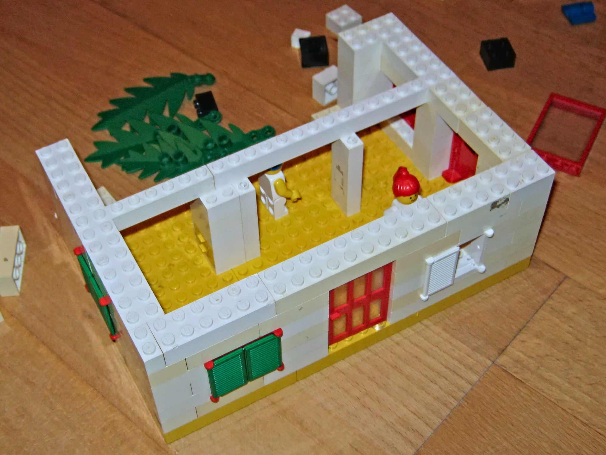 A house made of toy bricks. There are now solid walls, but no roof yet.